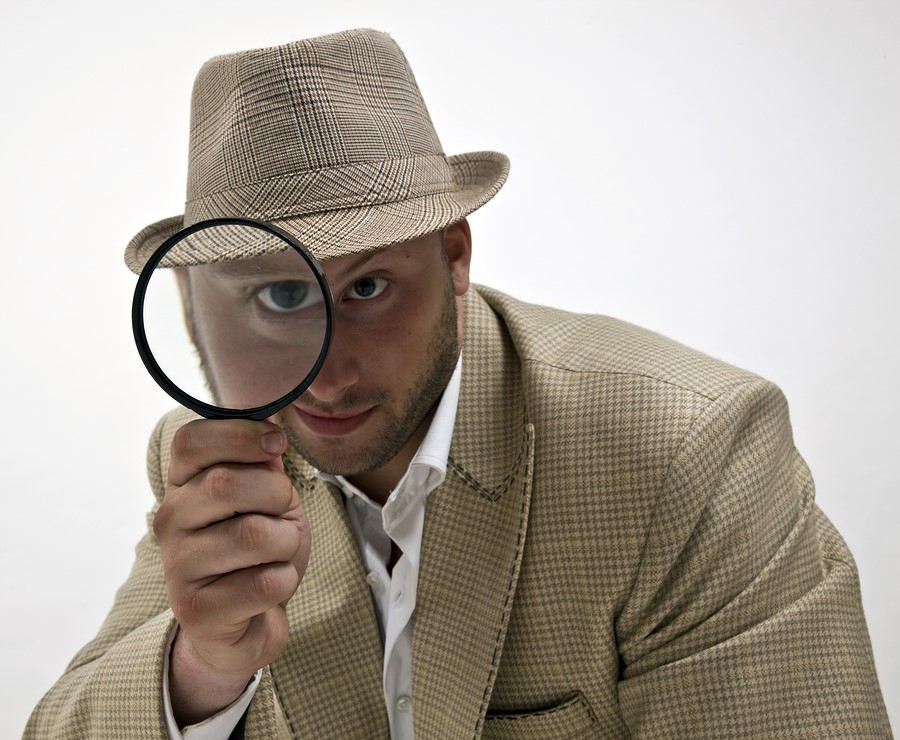 detective looking through magnifying glass