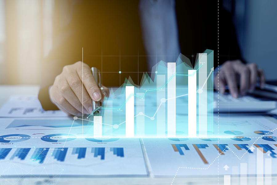 A business man examines data on financial documents, company financial reports, graphics showing financial and numerical growth data. The concept of financial management to grow and be profitable.