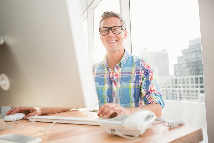 Male smiling while typing at computer
