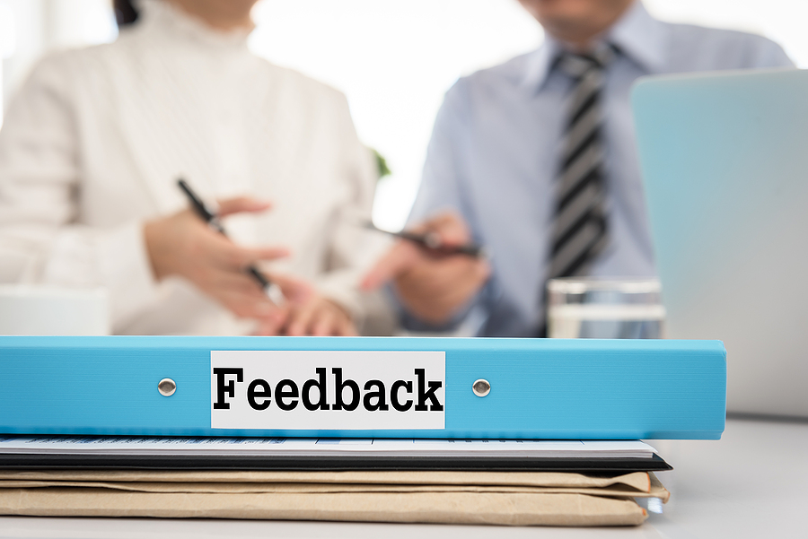 feedback on notebook in front of 2 people meeting