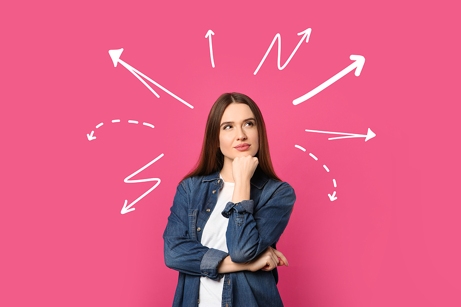 Skeptical woman thinking in front of pink background.