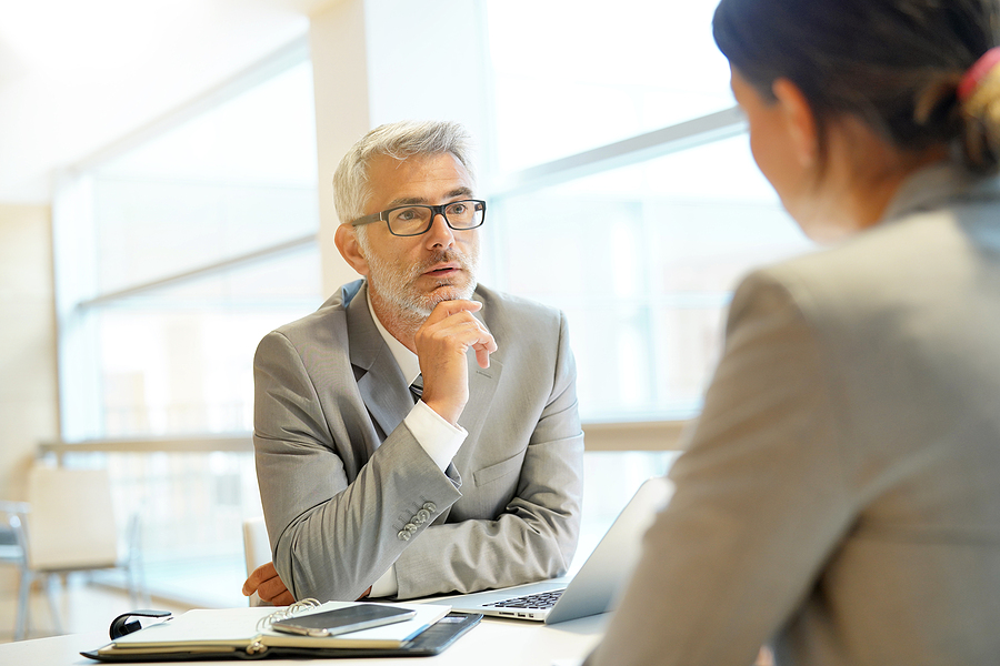 Manager listening to employee concerns at table.